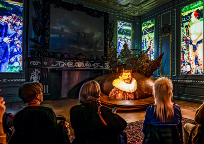 Multimediashow met portret JP Coen op wereldbol en beelden genocide banda op wanden geprojecteerd