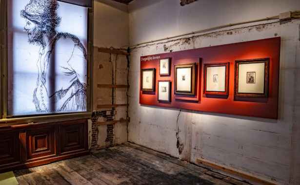 Rood paneel met etsen tegen ruwe wanden en lichtbak met geëtste manfiguur
