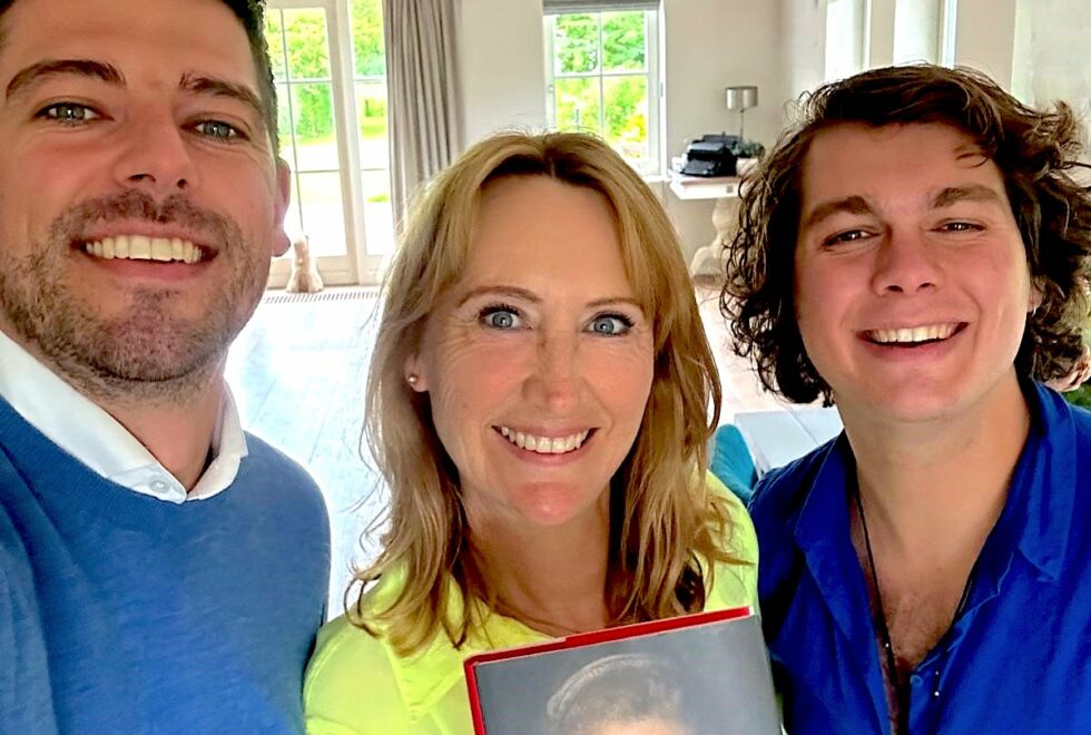 Foto van drie personen met boek